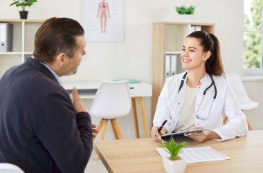 Pozitif doktor ya da hemşire hastane ofisinde bir hastaya tıbbi danışmanlık yapar. Görüşme sırasında sağlık uzmanı konuşuyor ve bakım ve tedavi sunuyor.