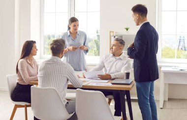 İş ekibi birlikte çalışıyor, bir toplantıda ya da bir ofiste brifing veriyor. Çeşitli profesyonel gruplar, iş ile ilgili konuları görüşmek üzere iletişim ve diyalog kuruyor..