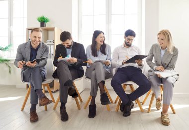 Bir grup mutlu, gülümseyen genç iş adamı konferans sırasında koltuklarda oturuyorlar ya da modern ofiste ellerinde mali belgeler olan seminerler düzenliyorlar. Şirket çalışanları düşman toplantısına hazırlanıyor..