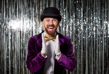 Şaşırmış ve mutlu bir adamın portresi. Alkışlayan, şaşırtıcı bir şekilde eğlenen, bir partide eğlenen, ışıltılı bir arka planda, neşeli bir kutlama ortamında zevk veren..