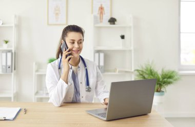 Hastanede dizüstü bilgisayar kullanırken hastayı arayan bir hemşire ya da doktor var. Sağlık uzmanları internet üzerinden sağlık hizmetleri ve internet danışmanlığı hizmeti sunar..