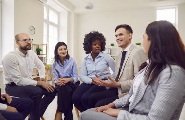 Resmi kıyafetler içindeki genç iş adamları iş projesini tartışıyor. Sandalyelerde daireler çiziyor ve ofiste görüşüyorlar. Şirket çalışanları yeni girişimler hakkında konuşuyor. Takım çalışması konsepti.