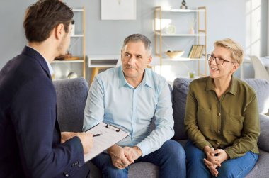 Profesyonel danışman ya da temsilci bir ofiste üst düzey müşterilerle bir toplantı yapıyor, sigorta, finansal yatırımlar ve gelecek planlar için yardım sağlama konularını tartışıyorlar..