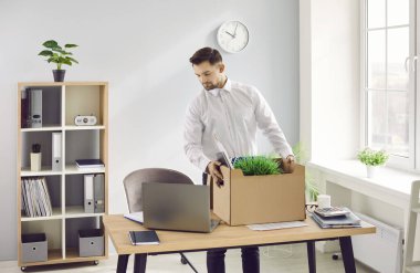 İşyerinin yanında duran bir kutu eşyasıyla işten atılan bir iş adamının portresi. Stresli, üzgün bir çalışanın ofisini taşıması. İşini ve işsiz konseptini kaybetmek.