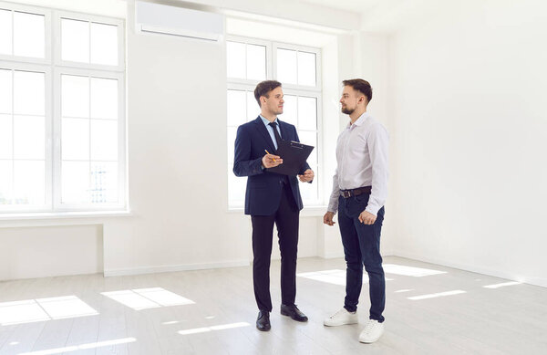 Перед покупкой мужчина консультирует риэлтора и дарит клиенту новый дом или офис. Профессиональный риэлтор или брокер, предоставляющий экспертные консультации по недвижимости.