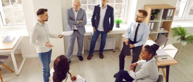 Bir grup iş adamı daireler çizip ofiste iş projesini tartışıyor. İş antrenörü, takım lideri ya da koç şirket çalışanlarıyla kalkınma stratejisi hakkında konuşuyor. Pankart.