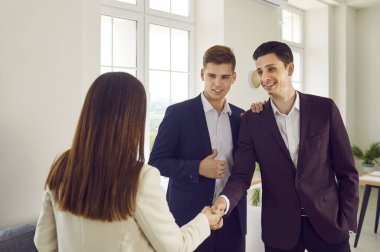 Modern ofiste duran ve iş arkadaşlarıyla tokalaşan zeki üç iş adamından oluşan bir grup. İş arkadaşları anlaşmaya varıyor veya yeni çalışanları selamlıyor.