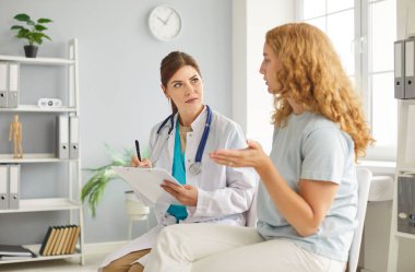 Değer veren genç bayan hemşire, doktor, bekçi konuşuyor. Sağlık kontrolü, muayene, bakıcı sohbeti gibi sağlık kontrolleri sırasında rehabilitasyon tedavisi gören bir kadına yardım etmek