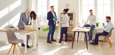 Ofiste birlikte çalışan bir grup iş adamı. Erkek, kadın iş arkadaşları ofiste iş görüşmeleri sırasında birbirleriyle konuşuyorlar. Akıllı gündelik giyinen iş arkadaşları proje tartışıyor, iletişim kuruyor.