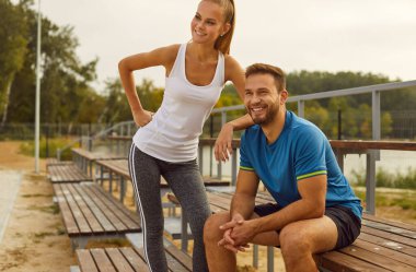 Aktif bir yaşam tarzını kucaklayan, pozitif bir çiftin portresi şehir parkındaki spor sahasında spor eğitimi alıyor. Birlikte spor yaptıklarında ya da spor yaptıklarında mutlulukları yayılıyor..