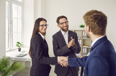 Ofiste duran ve anlaşmaya sevinen üç genç iş adamından oluşan bir grup greve gitti. Erkek kadınla tokalaşırken toplantıyı bitirir, kontrat imzalar ya da yeni çalışanı selamlar..