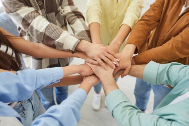 Arkadaşlarının ya da günlük giysiler içinde toplanmış bir grup öğrencinin kesilerek çekilmiş fotoğrafları bir araya getirilmiş ve kollarını bir yığın haline getirilmiş. Arkadaşlık, birlik ve takım çalışması kavramı..