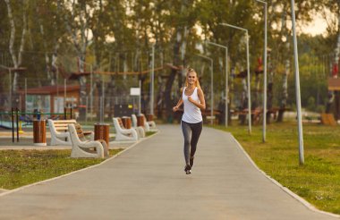 Mutluluk saçan bir kadın, şehir parkında ferahlatıcı bir koşuya çıkar. Açık havada koşuya katılıyor, sporu kucaklıyor, koşu sevinci ile şehir parkının manzaralı güzelliğini birleştiriyor..