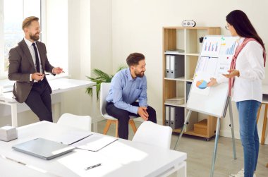 Üç iş adamından oluşan bir ekip işyerinde personel toplantısı yapıyor. Ofisin beyaz yönetim kurulunun yanında duran genç bir kadın pazar analizi sunumu yapıyor ve ilginç bir şey anlatıyor.