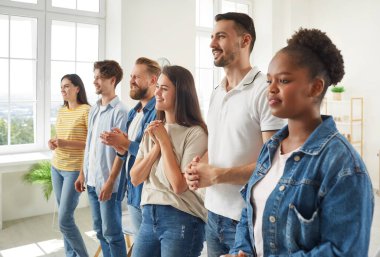 Neşeli, modern iş arkadaşlarıyla dolu bir ekip toplantıda liderlerini dikkatle dinliyor. Modern ofiste kuyrukta bekleyen, kot giymiş, sıradan giyinmiş çok ırklı insanlar. İş dünyasına moda yaklaşımı kavramı.
