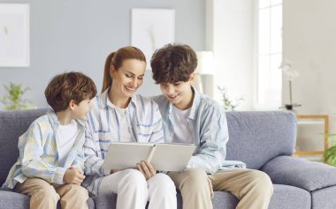 Aile annesini sevmek, küçük ve genç oğlu olan şefkatli bir kadın fotoğraf albümünde resimler izlemek, fotobook 'taki fotoğrafları incelemek, nostaljinin, çocuk anılarının tadını çıkarmak, birlikte gülümsemek ve gülmek.