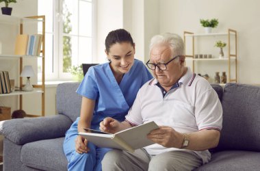 Huzurevindeki kanepede oturan ve ilginç bir kitap okuyan ve sessiz eğlencenin tadını çıkaran mutlu yaşlı bir adamla birlikte. Bakım konsepti