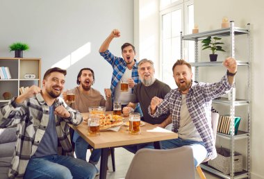 Heyecanlı mutlu erkek arkadaş portresi TV 'de maç seyrediyor bira ve pizza ile evde favori takımı destekliyor. Arkadaşlık, kiralama, spor, ev partisi konsepti.