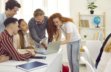 Profesör ve öğrenciler dizüstü bilgisayar projesinde birlikte çalışıyorlar masada oturuyorlar ve sınıfın yanında duruyorlar. Projeyi kontrol edip sonuçlandırıyorum. Üniversitede eğitim, üniversite konsepti.