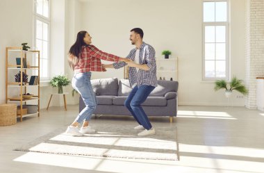 Mutlu ve genç çiftler neşeli danslar ve gülüşmeler. Hareketler ve gülümsemeler bir rahatlama ve birliktelik ortamı yaratır. Anlık görüntülerde aile, konforlu bir evde birlikte vakit geçirir..