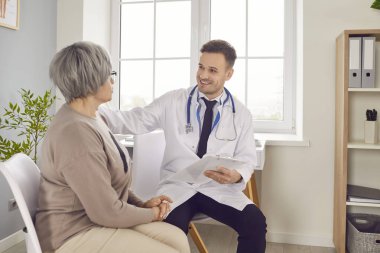 Genç gülümseyen doktor muayenesi, yaşlı kadınla ilgilenen erkek hemşire, muayene, muayene. Huzurevinin sakini, hastanedeki hasta, yaşlılara sağlık, güvenlik