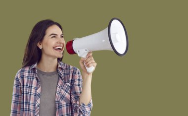 Ekose gömlek giyen genç esmer kadın gülüyor. Haki arka planda izole edilmiş hoparlörle gülüyor. İnsan duyguları, pazarlama ve satışlar, fotokopi alanı kavramlı reklam afişi.