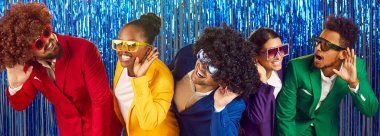 Bir grup pozitif insan, parlak mavi folyo perdelere karşı yapılan retro partisinde kulak misafiri olup eğleniyorlar. Renkli takım elbiseli çok ırklı arkadaşlar sırada bekliyor. Parti konsepti. Panoramik web pankartı.