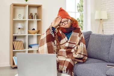 Hasta kıdemli bir adam, evdeki oturma odasındaki kanepede oturup dizüstü bilgisayar kullanan bir doktor, arkadaş ya da aileyle çevrimiçi video görüşmesi yaparak baş ağrısından muzdarip bir battaniyeye sarılmış, sağlıksız hissediyor..