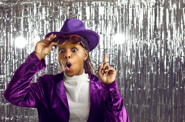 Portrait of stunned young African American woman on glitter studio background point consider deal or sale. Amazed black girl feel surprised with good offer. Recommendation and advertising.