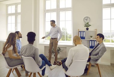 Group of business beautiful multinational people at business meeting working in spacious office in large business center. Launch concept, projects, planning, results, strategy, analytical report.