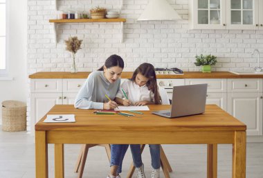 Çocuğu çizim yoluyla açığa çıkarmak. Profesyonel kadın psikolog seans sırasında genç kızla konuşur ve resim çizer. Kadın ve kız dizüstü bilgisayarın önünde ve renkli kalemlerle çizim yapıyorlar..