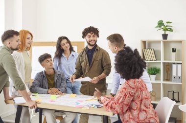 Team of happy young diverse multiethnic people meeting in the office, working on projects, discussing and developing a creative business idea together