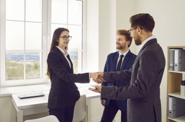 Ofiste duran ve anlaşmaya sevinen üç genç iş adamından oluşan bir grup greve gitti. Erkek kadınla tokalaşırken toplantıyı bitirir, kontrat imzalar ya da yeni çalışanı selamlar..