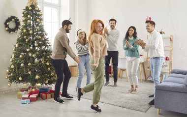 Happy overjoyed friends party, Happy New Year, Merry Christmas celebration dancing celebrating eve together, excited diverse people having fun enjoying celebration at home near tree, smiling, laughing