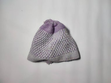 Beyaz arkaplanda beyaz desenli mor örülü bir şapka. Boşluğu kopyala.