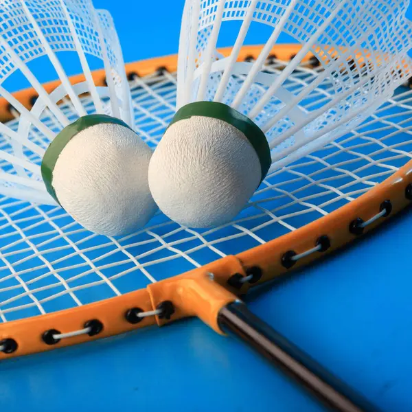 Badminton raketleri ve mekik horozu mavi arka grupta izole edildi