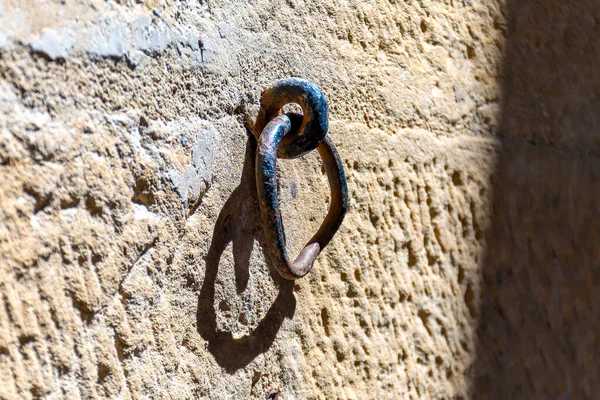 Explore the charm of history with our high-quality stock image of an antique, rustic ring embedded in a blurry wall. This heirloom, once used to tether the owner\'s steed, evokes a sense of timeless charm and heritage.