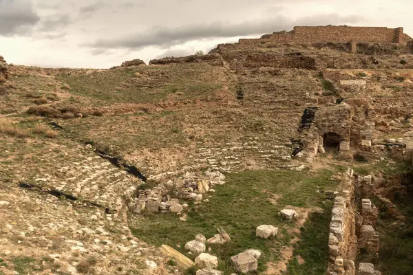 Calatayud, İspanya 'daki Bilbilis Roma Tiyatrosu' nun güzelliğini bu nefes kesici fotoğraf sayesinde keşfedin. Tribünlerin karmaşık detaylarını gösterin. Bu büyüleyici görüntü hisse senetleri için mükemmel. Başarı için portföyünüzü bununla konumlandırın