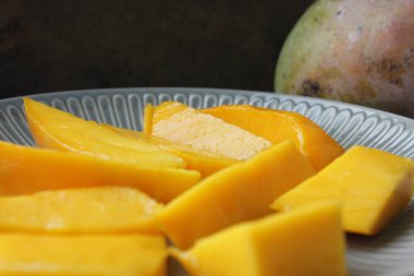 Mango meyvesi yakın plan. Sulu sarı mango rende yakın plan kesilmiş.