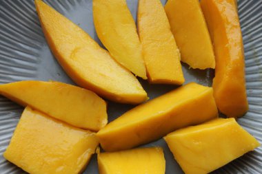 Mango meyvesi yakın plan. Sulu sarı mango rende yakın plan kesilmiş.