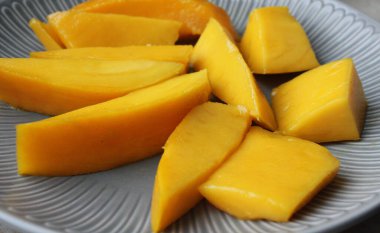Mango meyvesi yakın plan. Sulu sarı mango rende yakın plan kesilmiş.