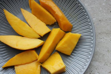 Mango meyvesi yakın plan. Sulu sarı mango rende yakın plan kesilmiş.