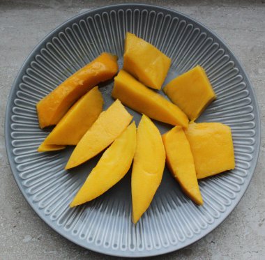 Mango meyvesi yakın plan. Sulu sarı mango rende yakın plan kesilmiş.