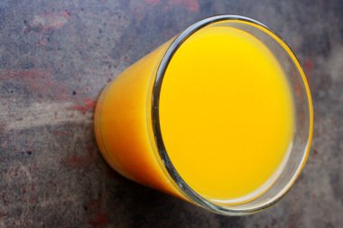 Mango meyvesi yakın plan. Sulu sarı mango rende yakın plan kesilmiş. Bir bardak sağlık suyu.