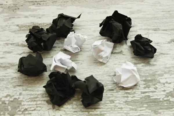 Weiße Und Schwarze Zerknüllte Papierkugeln Auf Schwarzem Hintergrund Das Konzept — Stockfoto