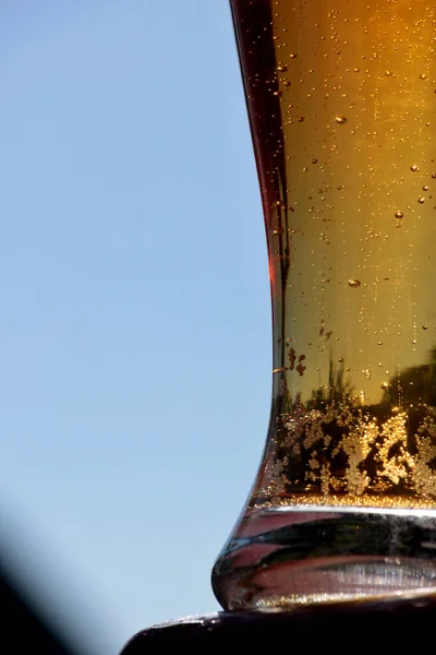 一杯冰凉的啤酒 在蓝天的映衬下 啤酒在杯子里 冰镇玻璃中的啤酒泡沫 — 图库照片