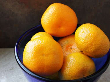 Olgun sarı Mandarin yakın çekim. Bir tabakta tüm mandalina ve soyulmuş mandalina.