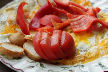 Ekmek tostlu kızarmış yumurta, taze kırmızı domates ve biberli kahvaltı.