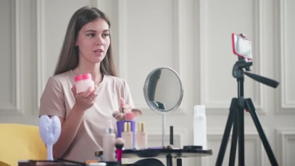 블로거는 화장품에 자신의 인상을 공유하며 구독자들에게 조언을 스마트폰으로 삼각대 Vlog — 비디오