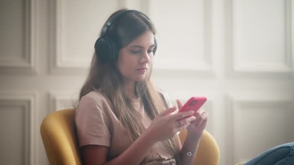 스마트폰 헤드폰을 근심없는 청소년 청소년기를 보내고 여가를 보내는 소녀의 앱에서 — 비디오